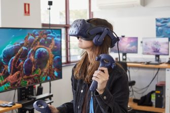 Student using virtual reality headset and controls in 3D Visualisation Aesthetics Lab.