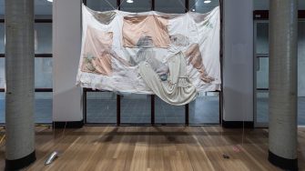 Trinity Johnson, ‘Dreaming of this’ (2025). Found and recycled fabrics and bedding, eucalyptus oil, acrylic medium, thread, beads, earthenware ceramics, 210cm x 165cm. Photograph: Anna Kucera.