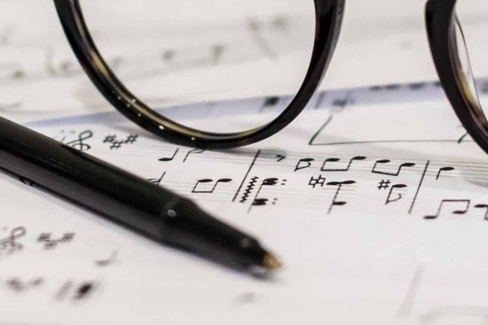 musical notation on a page, with a pen and glasses