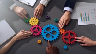Teamwork of businesspeople work together and combine pieces of gears. Partnership and integration concept