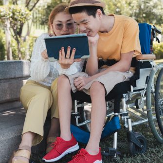 Student on wheelchair learning on a tablet .