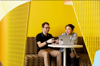 Two alumni in cafe with laptop