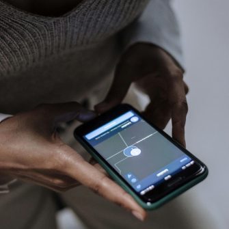 Close up of  a person holding a phone with a location app open