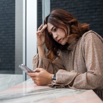Concerned woman looking at her smartphone