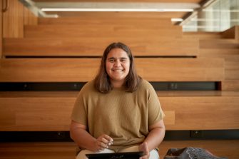 Art and design students discussing work inside the Red Center build enviroment study space.