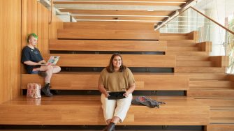 Art and design students discussing work inside the Red Center build enviroment study space.