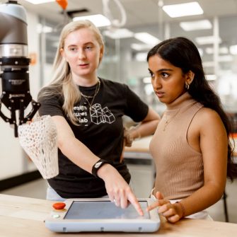 ADA Technician and student working with a collaborative robot.