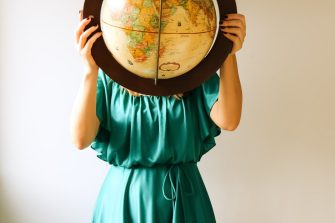 a woman holding a globe in front of her face
