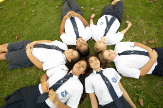 a group of children laying on the grass making a shape of star