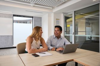 AGSM students working together from a laptop in a classroom on campus