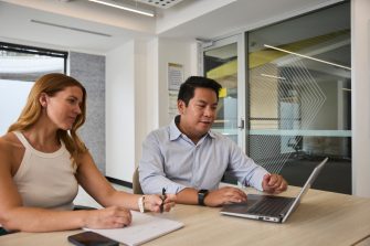 AGSM students working together from a laptop in a classroom on campus