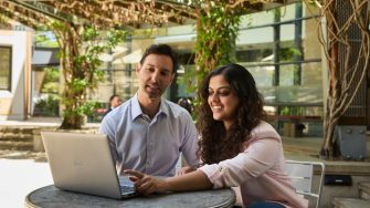 AGSM at UNSW students working together with a laptop outside in the courtyard on campus