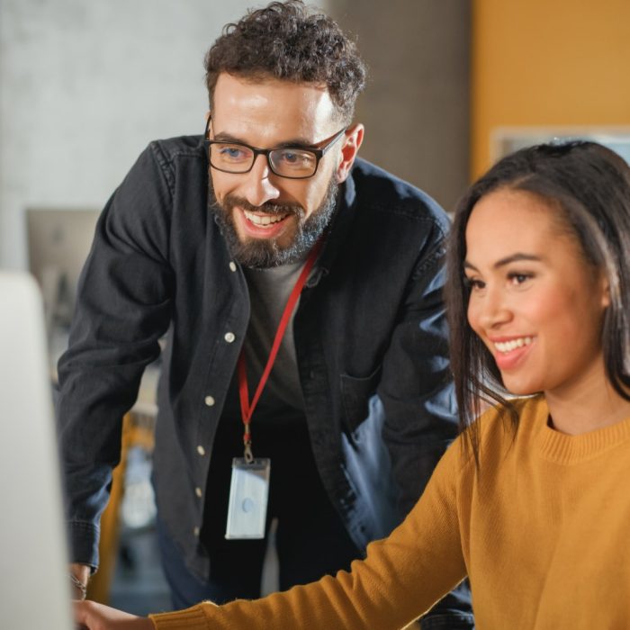 Lecturer Helps Scholar with Project, Advising on Their Work. Teacher Giving Lesson to Diverse Multiethnic Group of Female and Male Students in College Room, Teaching New Academic Skills on a Computer.
