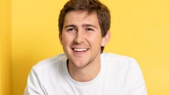 Kurt Walkom smiles in a pearler shirt against a yellow background