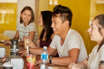 Students relaxing with computers, talking and studying at Kensington UNSW