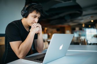 Man with headphones using a Macbook