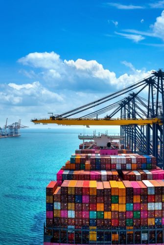 Aerial view of cargo ship and cargo container in harbor.