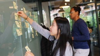 woman in grey shirt using post it notes