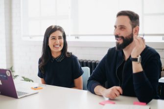 Two people smiling while discussing