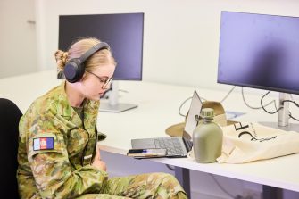 A woman wearing headphones at her computer