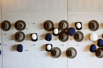 A collection of military hats hanging on a wall