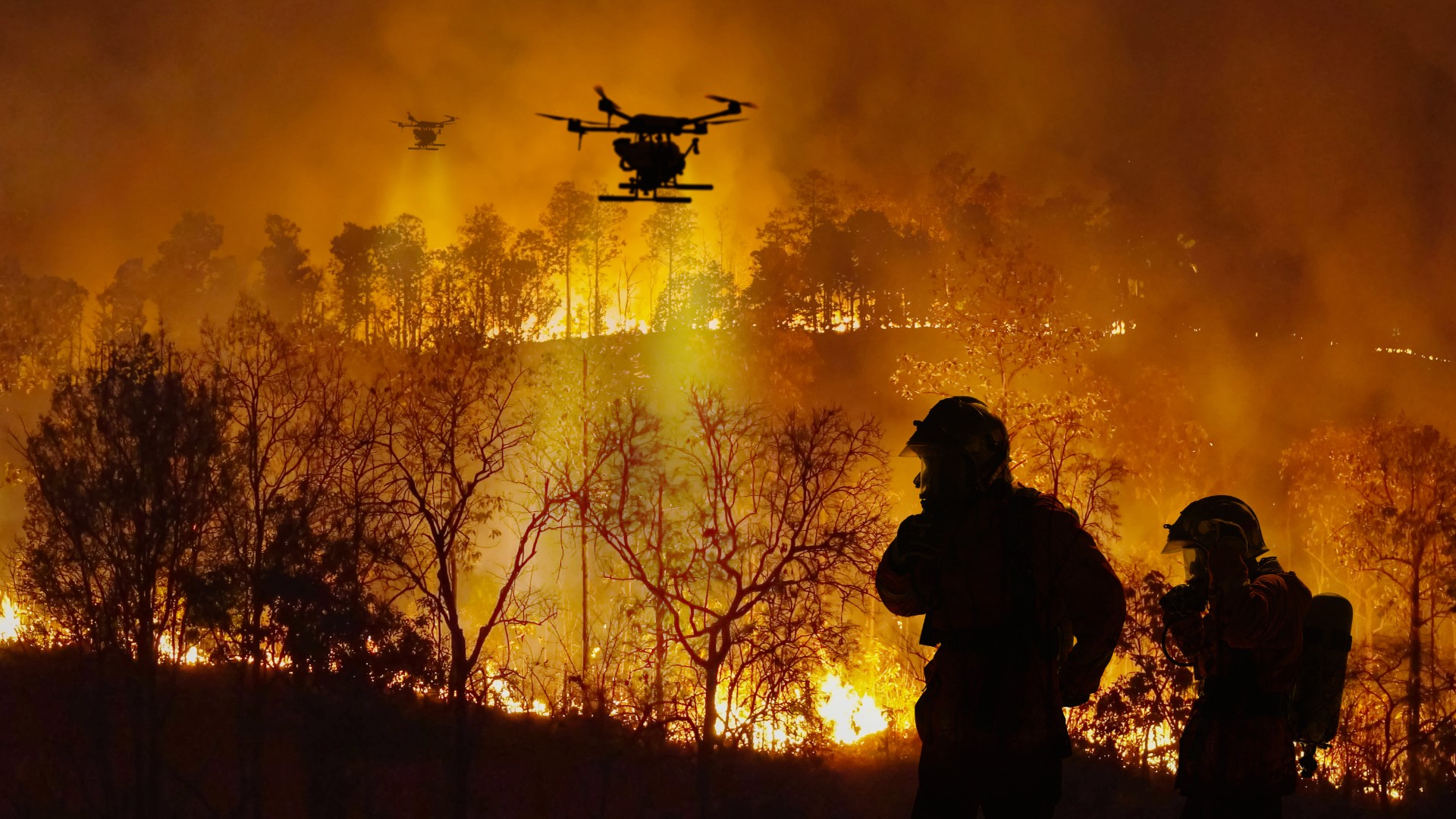 Firefighting drones spray chemicals to help control wildfire.