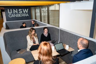 UNSW Canberra employees sitting in a booth