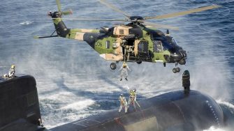 Helicopter airlifting military personnel