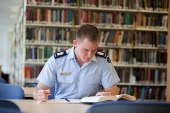 Student in uniform working in library