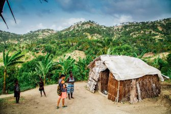 People standing in front of a hut