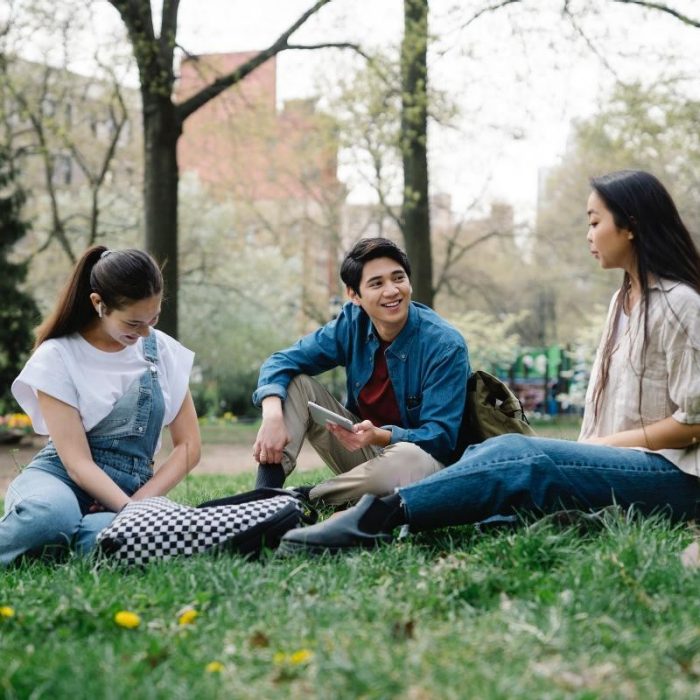 Three people in conversation on a lawn