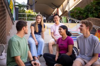 A group of students sitting and chatting on the Basser Steps on Kensington Campus