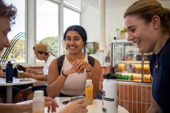 A group of students chatting while sitting at a table at Homeground cafe on UNSW Kensington Campus