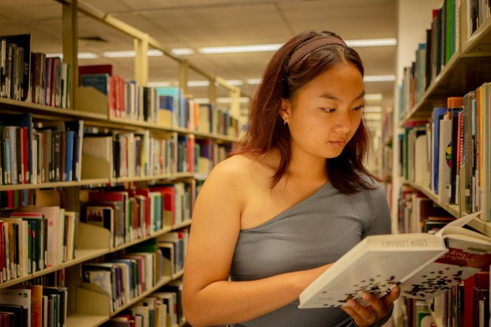 A student browsing the library shelves