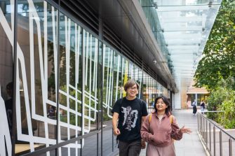 Two students chatting while walking through Kensington Campus