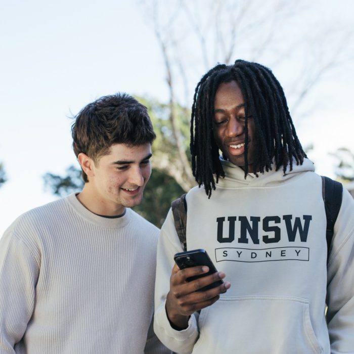 Students using their phones while on the main walkway