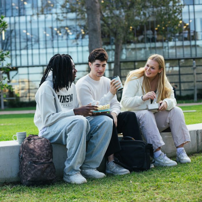 Students chatting and laughing while eating lunch on campus
