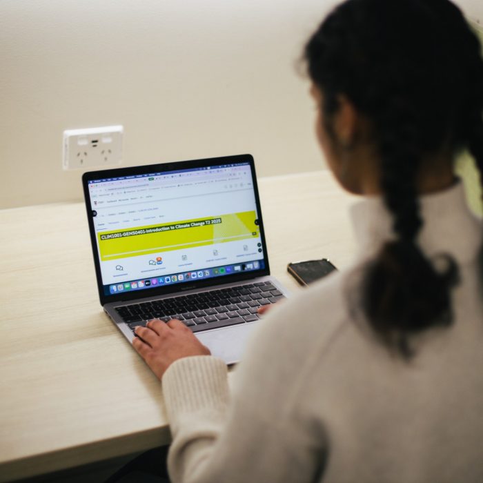 Student looking at a course on Moodle on their laptop
