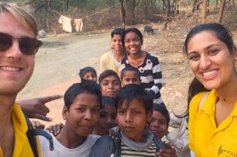 Two students with a group of Indian children