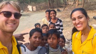 Two students with a group of Indian children