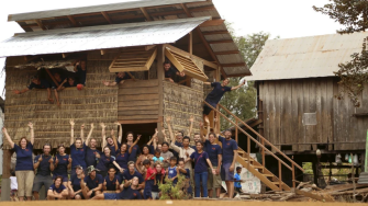 A group of engineers and locals in front of a house in Cambodia