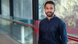 Headshot of Naras Rao with a glass window background