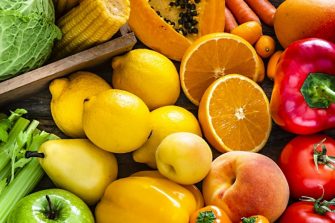 High angle view of a large assortment of healthy fresh rainbow colored organic fruits and vegetables. The composition includes cabbage, carrots, onion, tomatoes, raw potato, avocado, asparagus, eggplant, celery, cucumber, broccoli, squash, lettuce, spinach, lemon, apples, pear, strawberries, papaya, mango, banana, grape fruit, oranges, kiwi fruit among others.