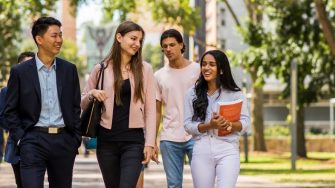 4 Students walking and talking on campus