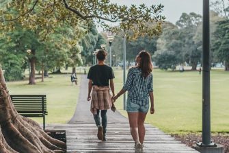 Students walk beneath tree on campus