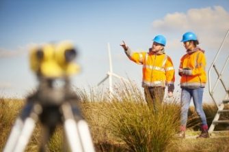 Two surveying engineers at wind turbine farm