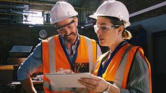 Man and woman wearing hard hats and high vis