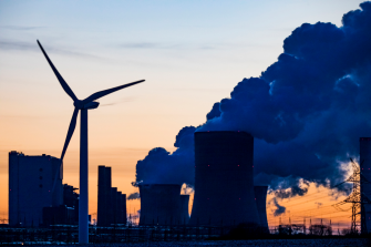 Germany, North Rhine Westphalia, Niederaussem, Wind turbine with lignite power station in background