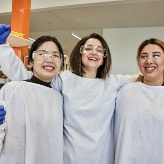 3 people in a lab, smiling