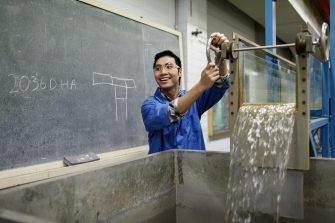 Engineer using water siphoning machine in workshop